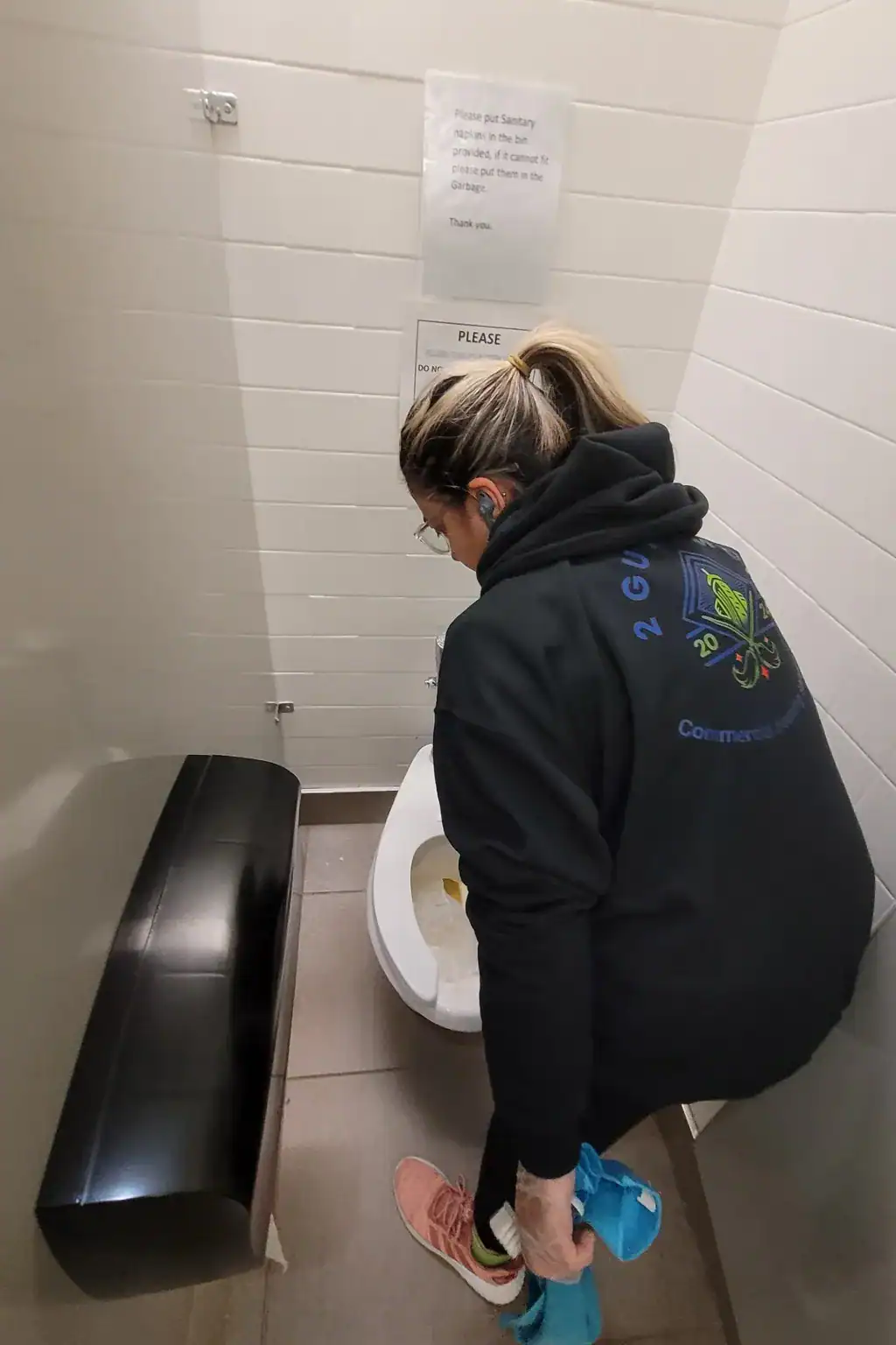 Commercial bathroom cleaning in North York with a professional cleaner sanitizing