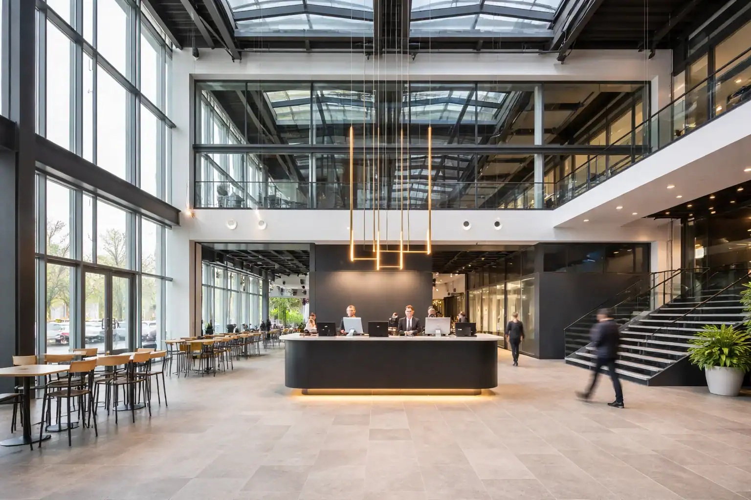 Modern glass office reception atrium with large windows, central reception desk, and open lobby in a commercial office building