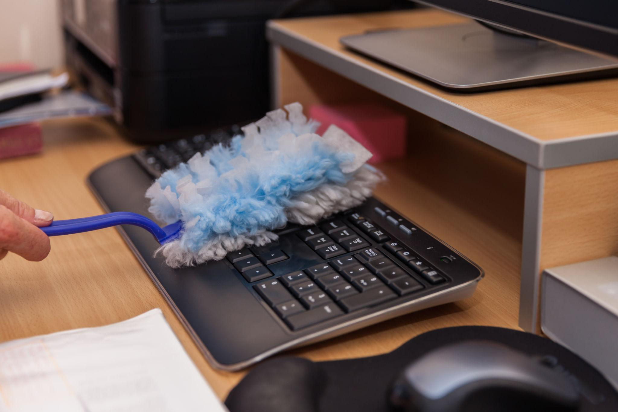 Dusting office surfaces to reduce dust in an Aurora workplace